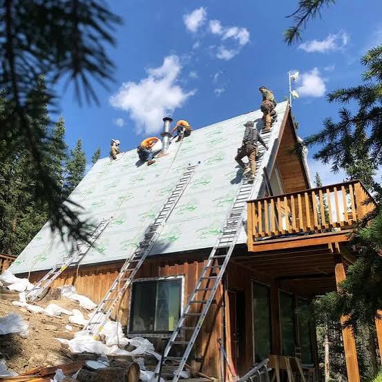 Priceless Perfection crew installing underlayment on a steep A-frame roof