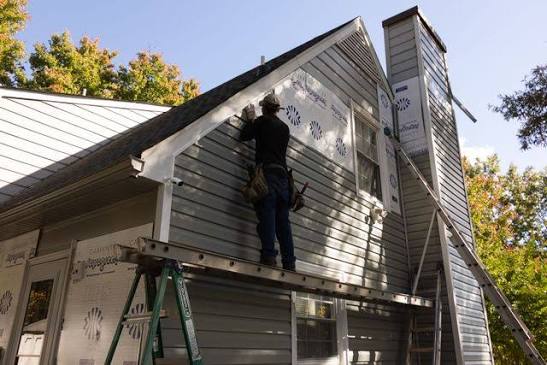 Siding installation in progress on a gable end