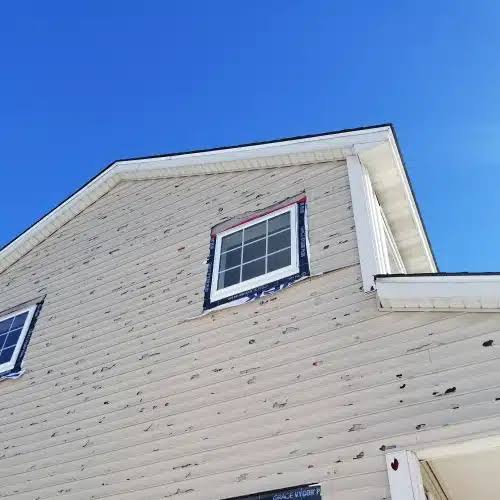 Hail-damaged siding before repair